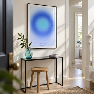 Aura Poster, framed on the wall of a bright modern hallway in a renovated UK terrace with a white wall and pale timber floor
