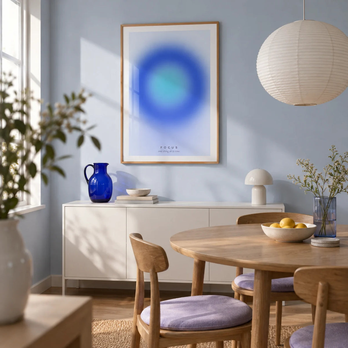 Aura Poster, framed on the wall of a compact contemporary dining room in a first flat (22-28) with a pale blue wall and a round oak table