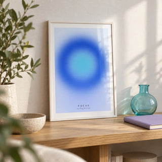 Aura Poster, a small A4 framed print leaning on a pale oak shelf in a living room