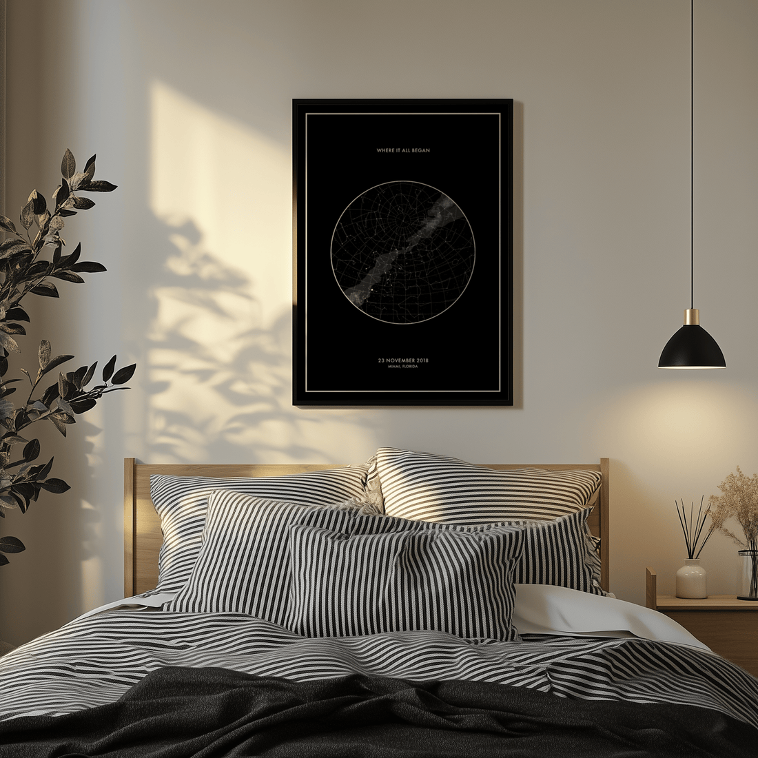 Black and white custom star map print above a bed with striped bedding, lit by warm afternoon sun