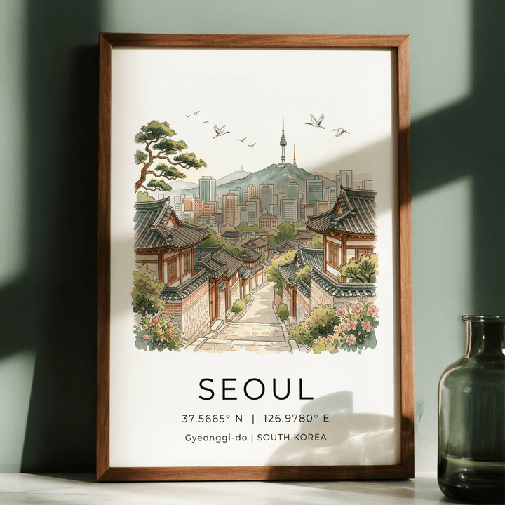 Framed Seoul Landscape Art Print showing traditional houses and skyline with birds against a green wall with a glass jar nearby