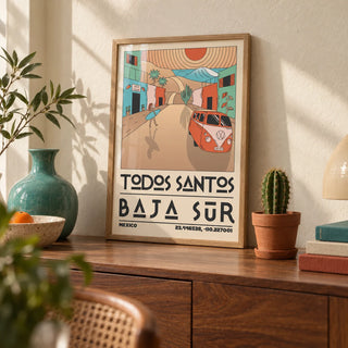 Baja Sur Art Print, a small A4 framed print leaning on a walnut sideboard in a living room