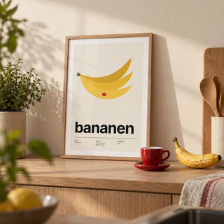 Bananas Wall Art, a small A4 framed print leaning on a pale oak kitchen worktop