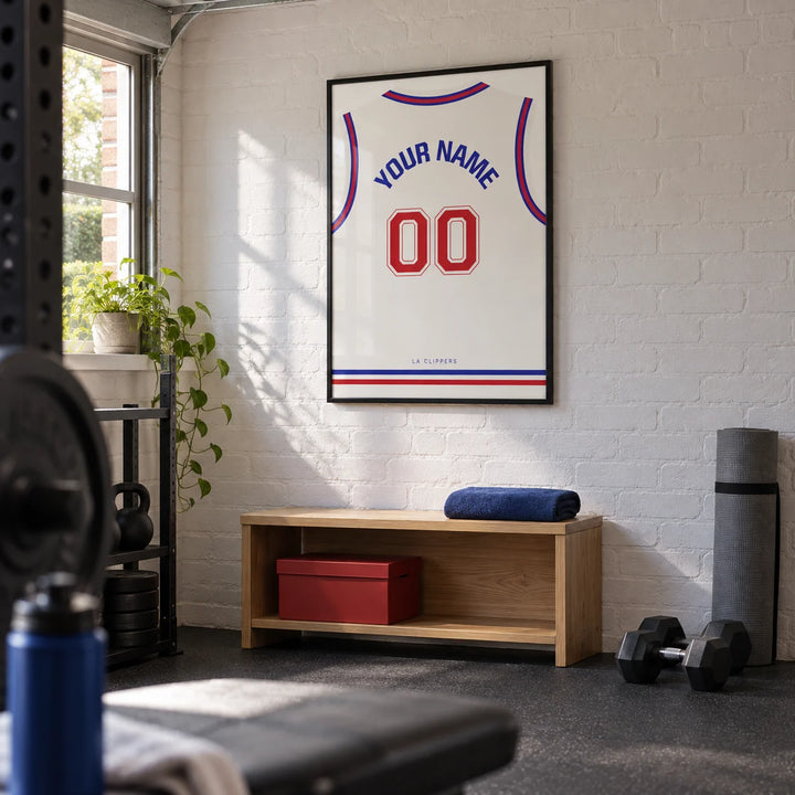 Basketball Jersey Poster in Plain White with Red Number, framed on the wall of a compact home gym in a converted UK garage with white painted brick and a charcoal rubber floor