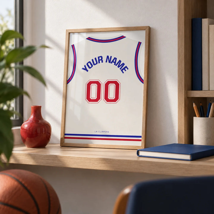 Basketball Jersey Poster in Plain White with Red Number, a small A4 framed print leaning on a pale oak shelf in a home office