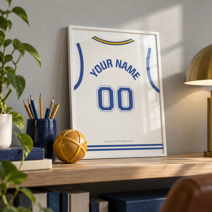 Basketball Jersey Poster in White with Blue Number, a small A4 framed print leaning on a pale oak shelf in a home office