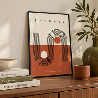 Terracotta Bauhaus Poster, a small A4 framed print leaning on a walnut sideboard in a living room