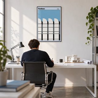 Bauhaus Architecture Art Poster, framed on the wall of an architect's studio with a white wall and a concrete floor in a home office