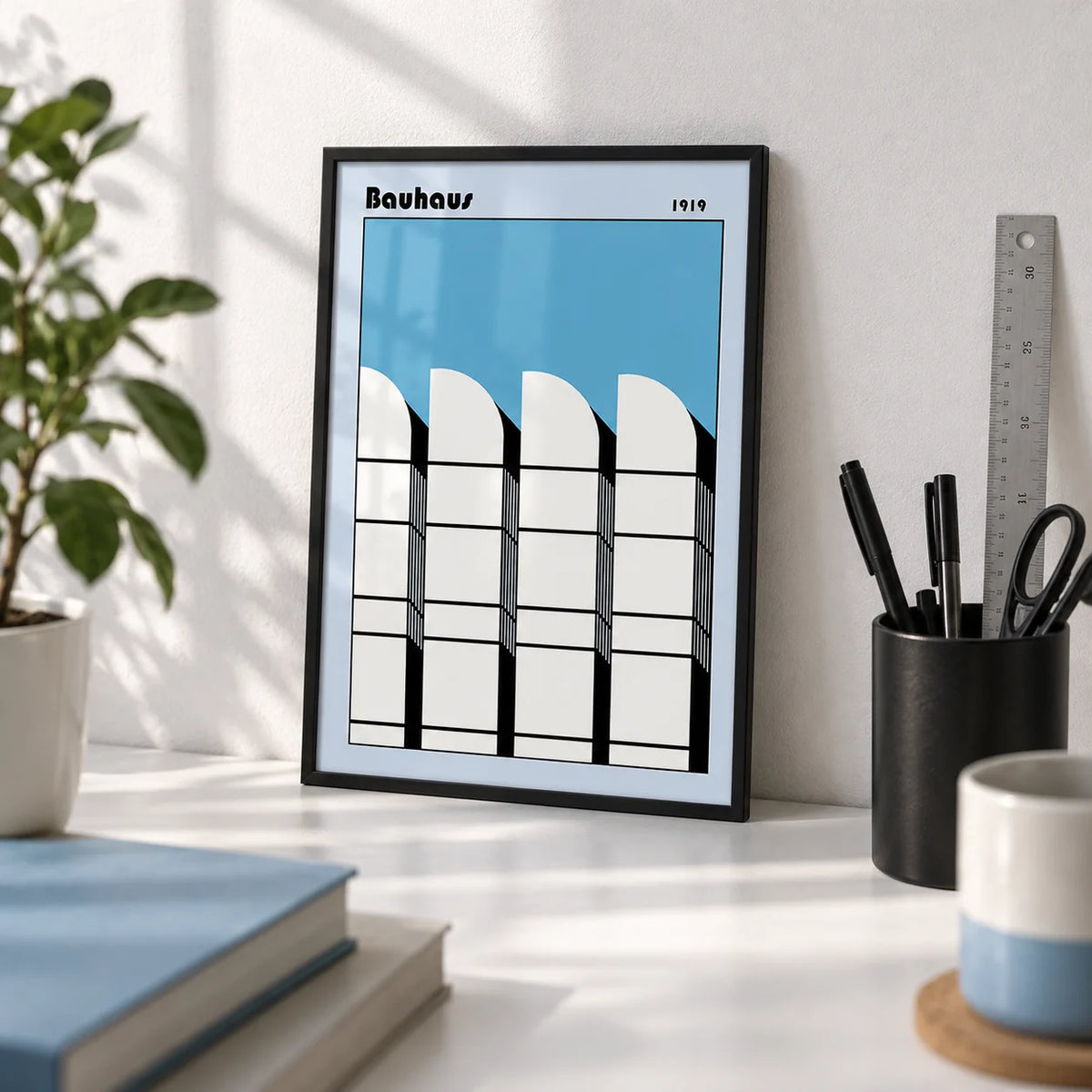 Bauhaus Architecture Art Poster, a small A4 framed print leaning on a white desk