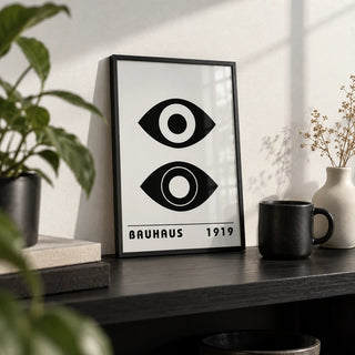 Bauhaus Art Print, a small A4 framed print leaning on a black shelf in a living room