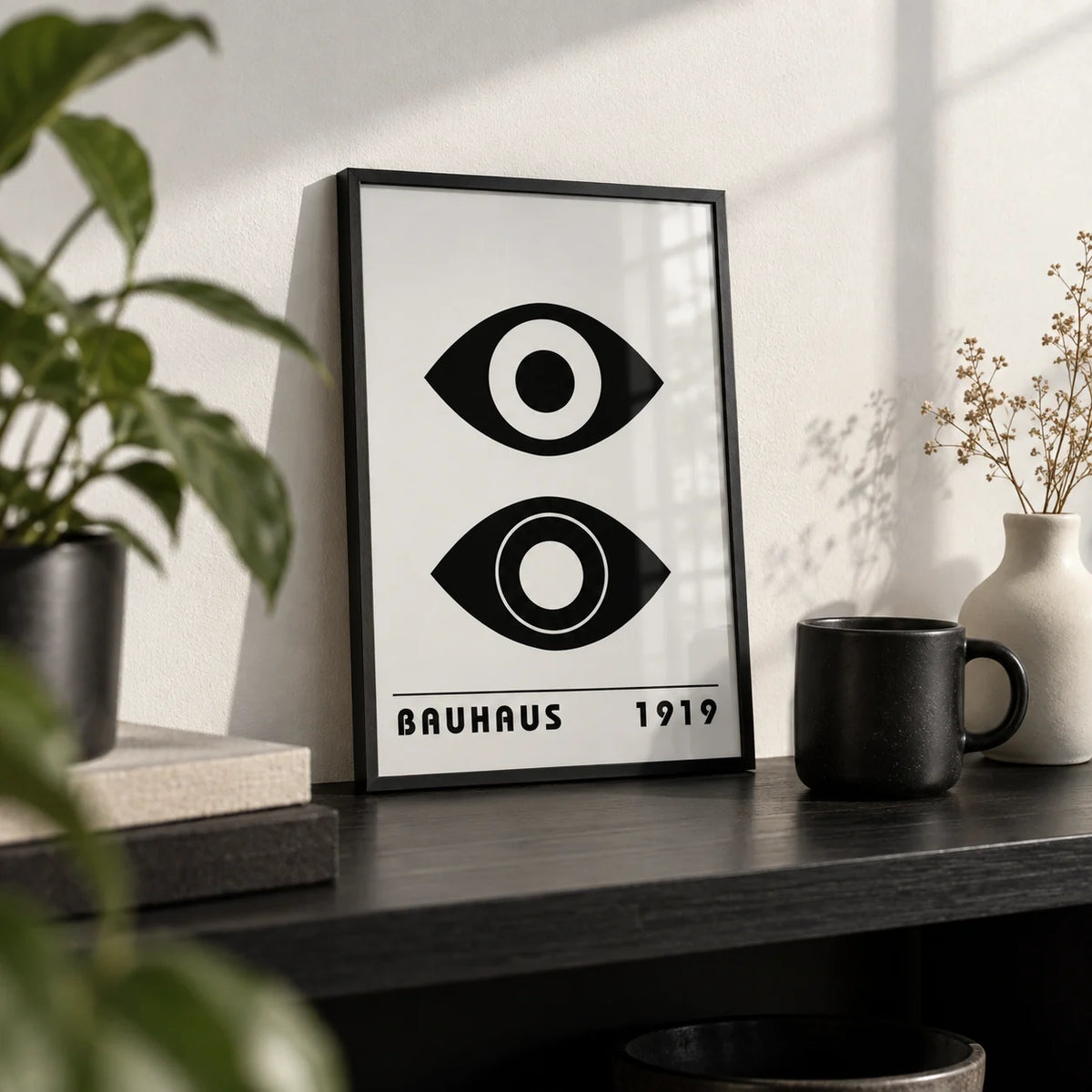 Bauhaus Art Print, a small A4 framed print leaning on a black shelf in a living room