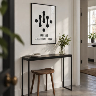 Bauhaus Art Black and White, framed on the wall of a compact architectural hallway in a design-led UK flat with a white wall and a smooth concrete floor