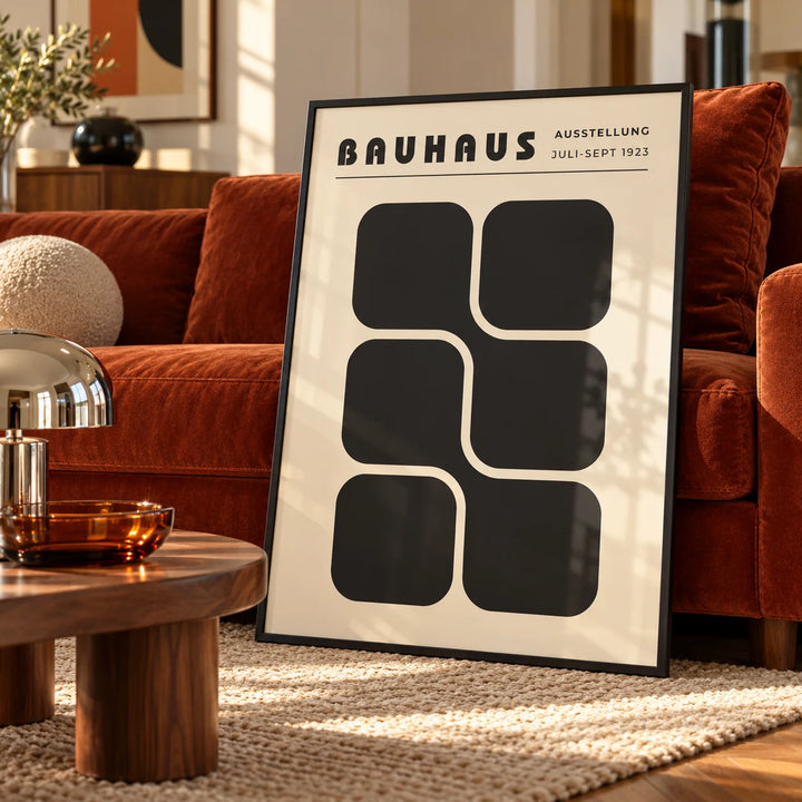 Bauhaus Art Black and White, a framed print leaning on a velvet sofa in a living room