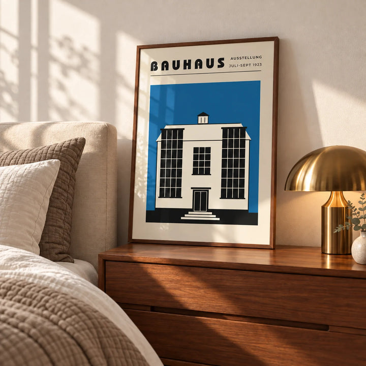 Bauhaus Poster Blue, a framed print leaning on a walnut bedside chest in a calm mid-century bedroom