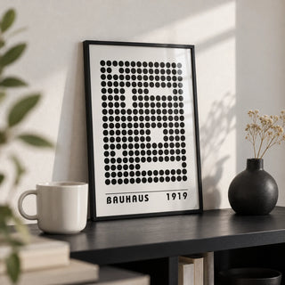 Bauhaus Prints, a small A4 framed print leaning on a black shelf in a living room