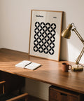 Minimalist mid century wall print with repeating circle-based forms in black and tan tones.