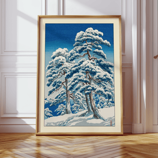 Framed view mockup of Hasui Kawase winter landscape print featuring snowy pine canopies