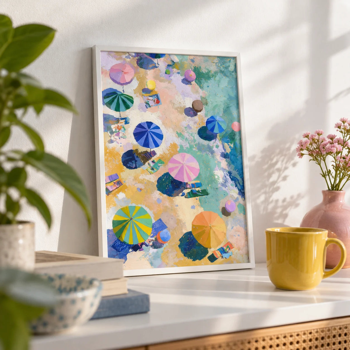 Beach Umbrellas Print, a small A4 framed print leaning on a white shelf in a living room