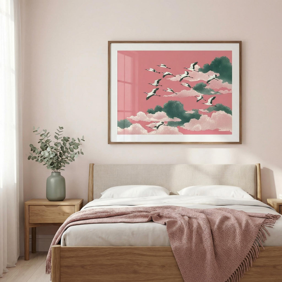 Framed artwork of birds flying over clouds on a pink background above a bed in a bedroom.