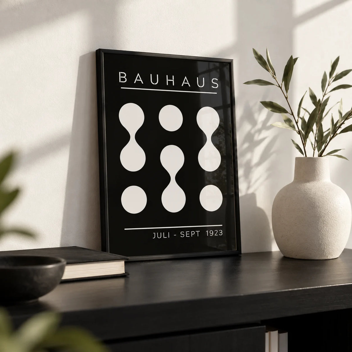 Black and White Geometric Art, a small A4 framed print leaning on a black shelf in a living room