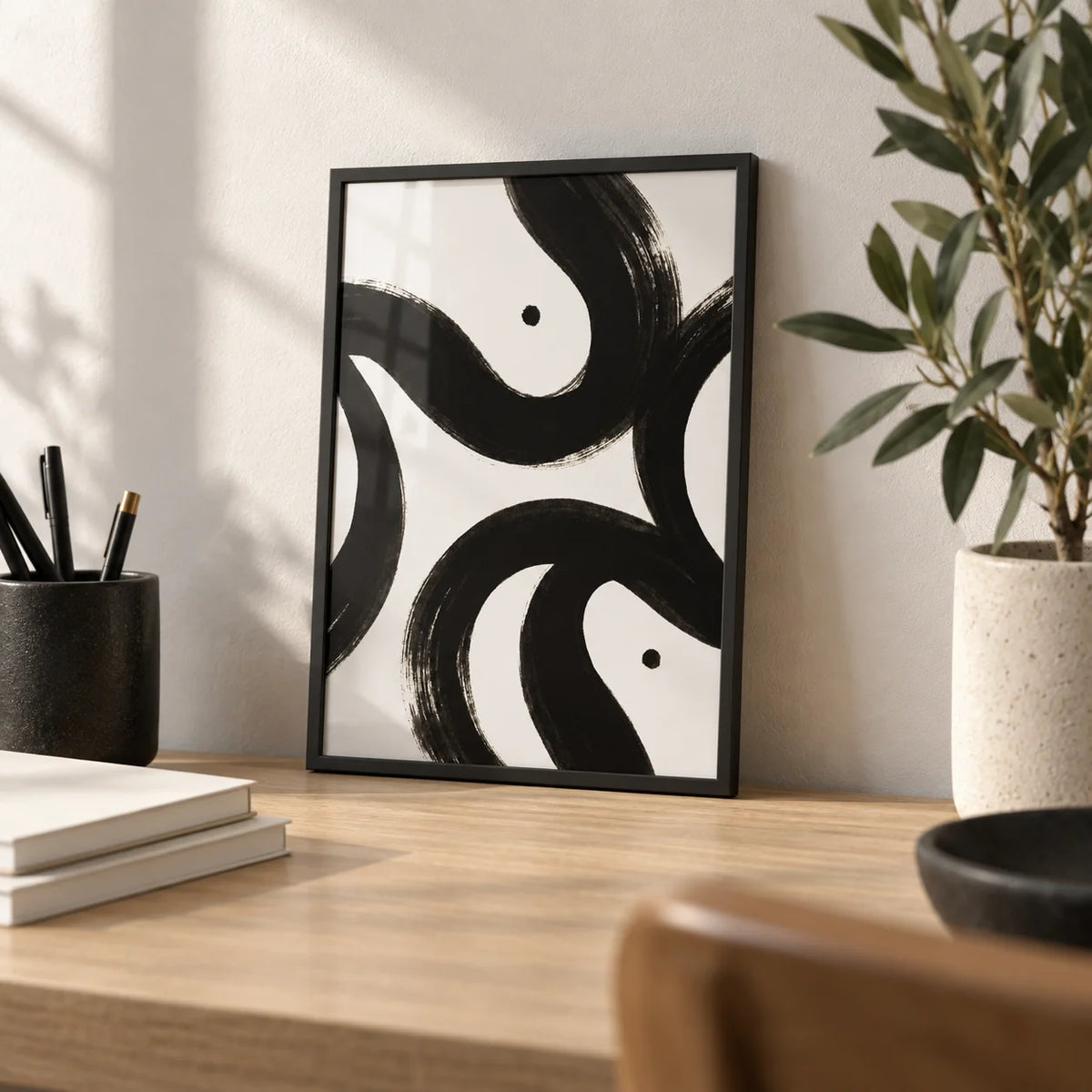 Black and White Posters, a small A4 framed print leaning on a light oak desk
