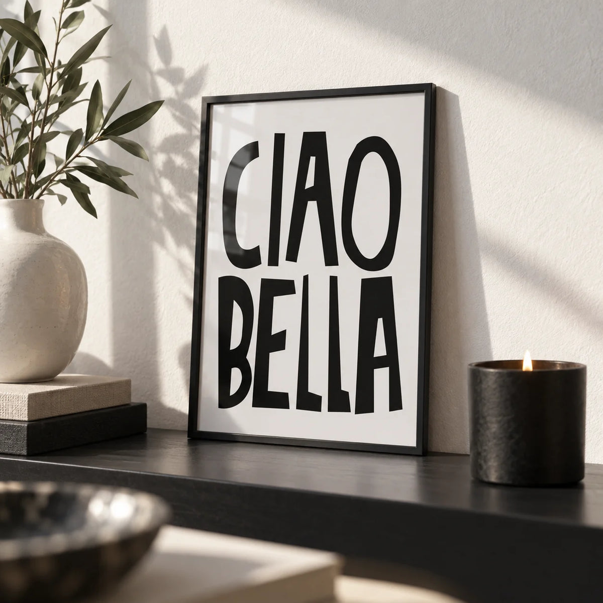 Black and White Typography Poster, a small A4 framed print leaning on a black shelf in a living room