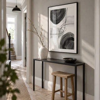 Black And White Wall Art, framed on the wall of a bright narrow hallway in a renovated UK terrace with a soft grey wall and original pale timber floorboards