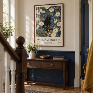 Black Cat Art Print, framed on the wall of a terraced house hallway with a navy lower wall and a cream upper wall