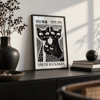 Black Cat Poster Art, a small A4 framed print leaning on a black sideboard in a living room