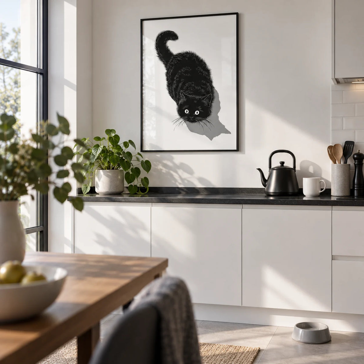 Black Cat Print, framed on the wall of a bright white kitchen with a black worktop