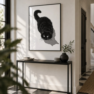 Black Cat Print, framed on the wall of a crisp hallway with a white wall and a black and white plain floor