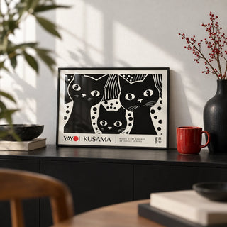 Black Cat Wall Art, a small A4 framed print leaning on a black sideboard in a living room