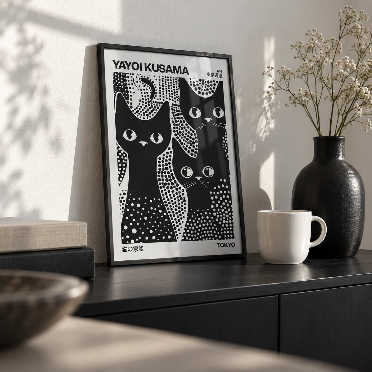 Black Cats Poster, a small A4 framed print leaning on a black sideboard in a living room