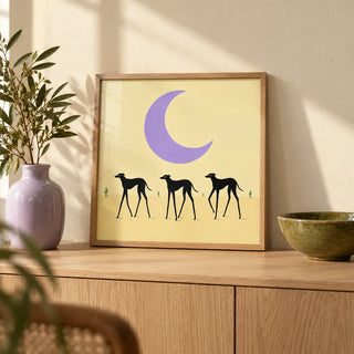 Black Dog Art Print, a small A4 framed print leaning on a pale oak sideboard in a living room