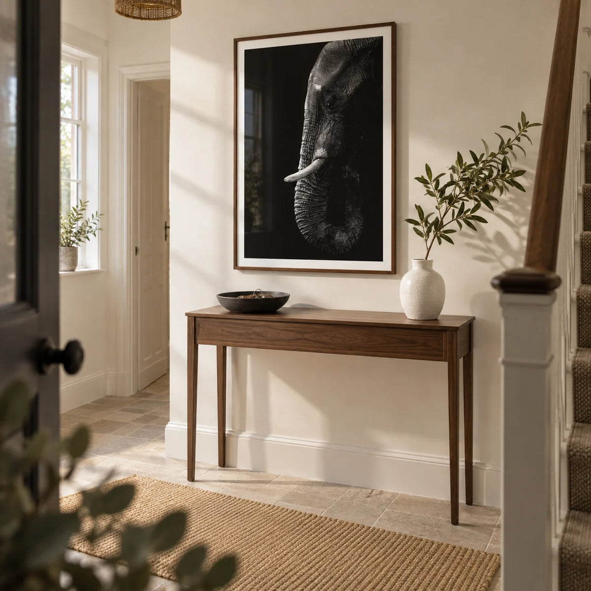 Black Elephant Wall Art, framed on the wall of a welcoming hallway in a renovated UK semi-detached home with a warm white wall and pale stone floor