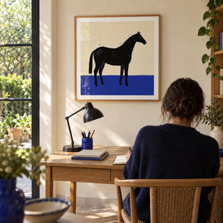 Black Horse Wall Art, framed on the wall of a compact home study with a warm cream wall and a view into a small garden