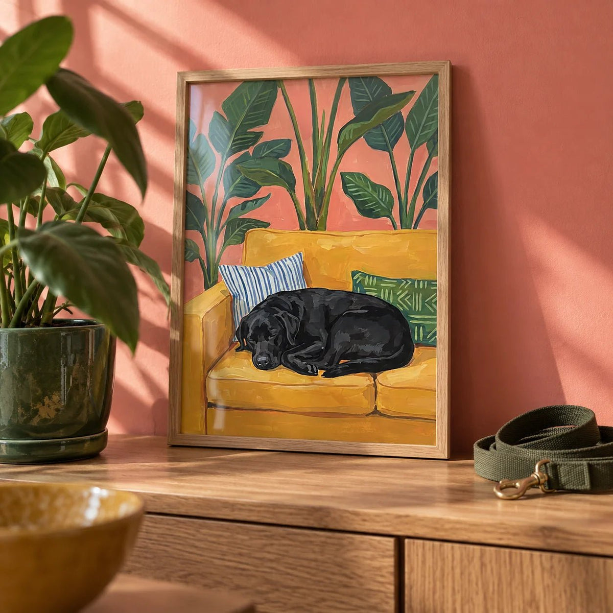Black Lab Wall Art, a small A4 framed print leaning on an oak shelf in a living room