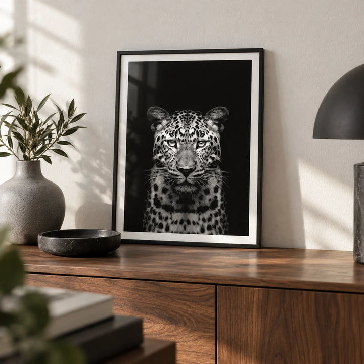 Black Leopard Art Print, a small A4 framed print leaning on a walnut sideboard in a living room