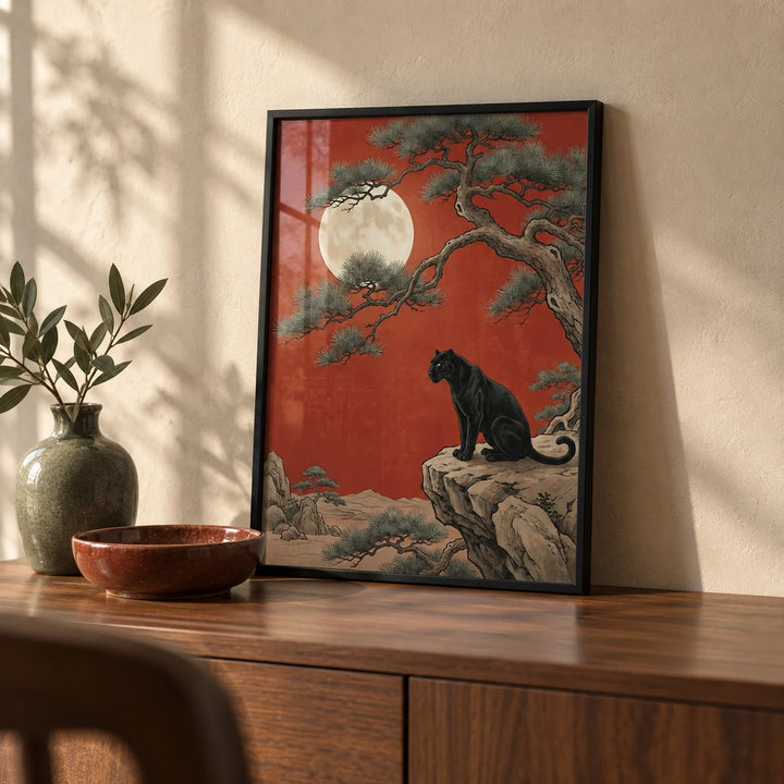 Black Panther Moon Print, a small A4 framed print leaning on a walnut sideboard in a living room