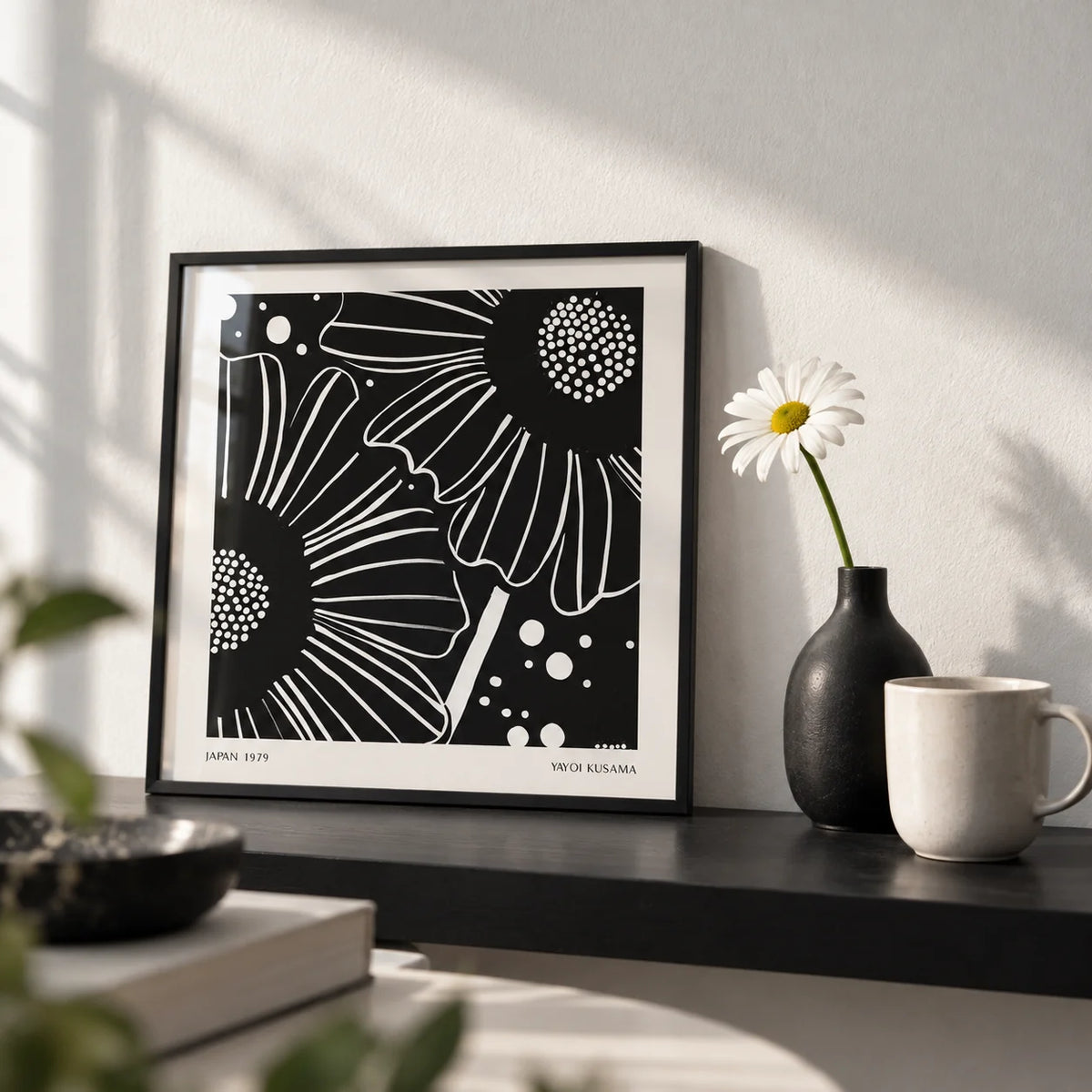 Black White Floral Art, a small A4 framed print leaning on a black shelf in a living room