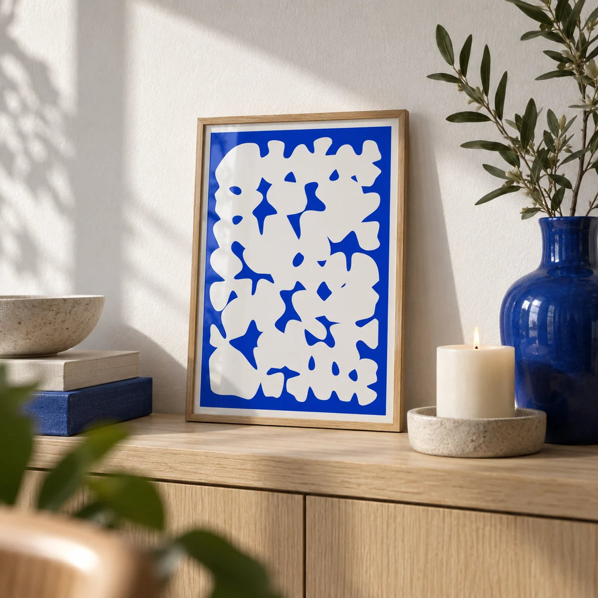 Blue And White Modern Art, a small A4 framed print leaning on a pale oak shelf in a living room