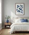 Bedroom with a bed, nightstand, and wall art featuring blue flowers.
