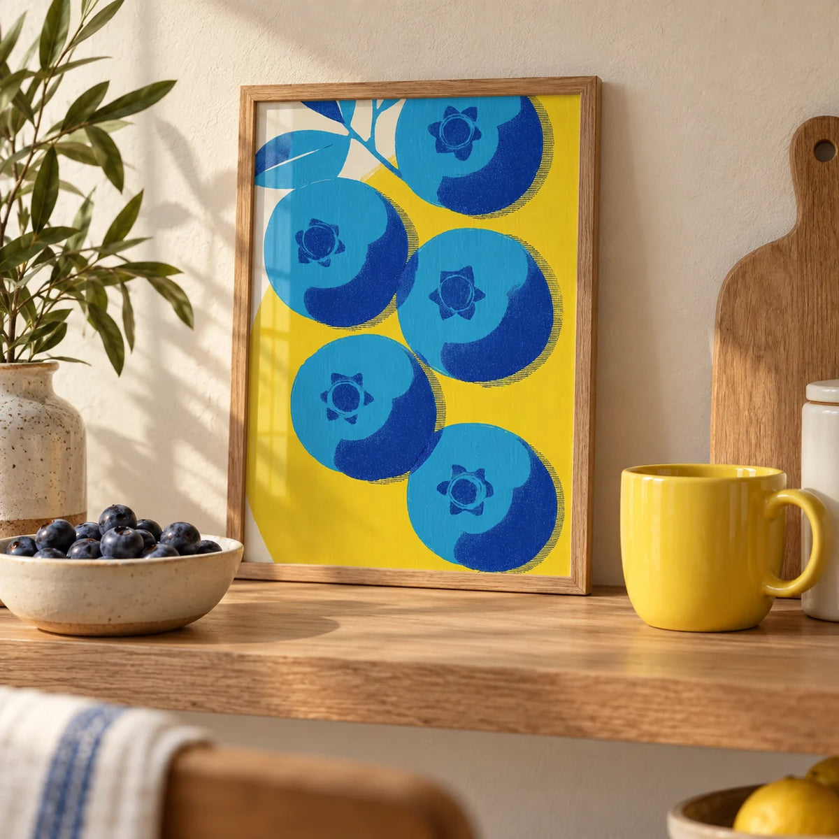 Blueberry Wall Art, a small A4 framed print leaning on an oak kitchen shelf