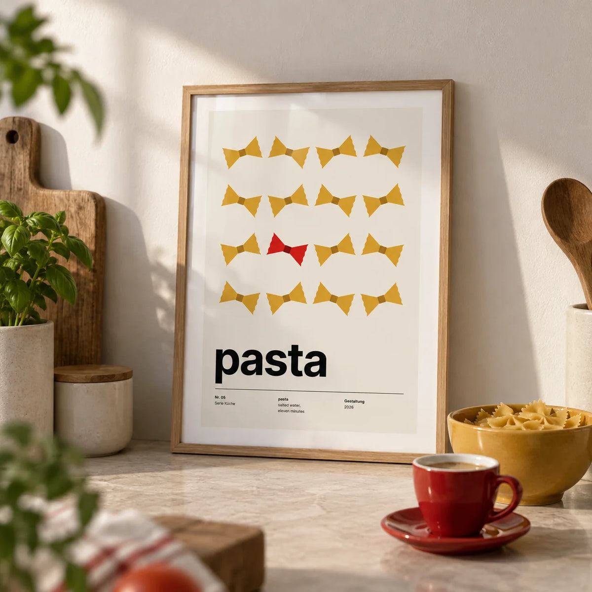 Bow Tie Pasta Print, a small A4 framed print leaning on a pale stone kitchen worktop