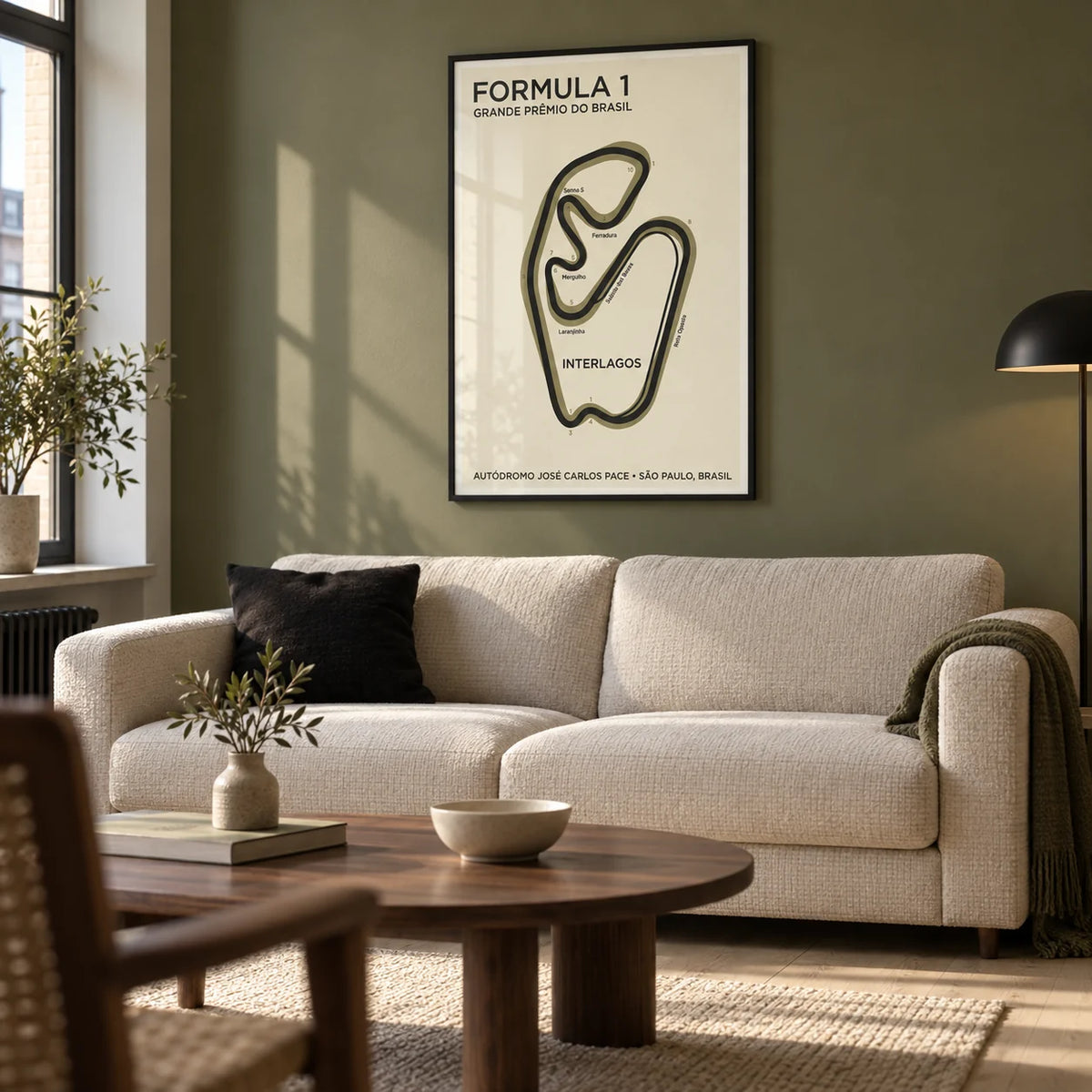 Brazilian Race Circuit Poster, framed on the wall of a design-led living room in a UK city flat with an olive painted wall and pale oak floor