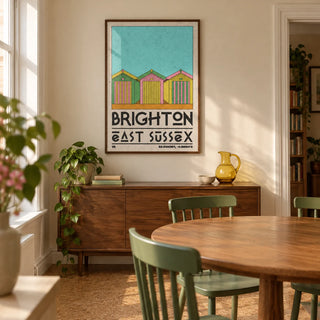 Brighton Travel Print, framed on the wall of a compact dining room in a characterful UK flat with warm cream walls and a plain cork floor