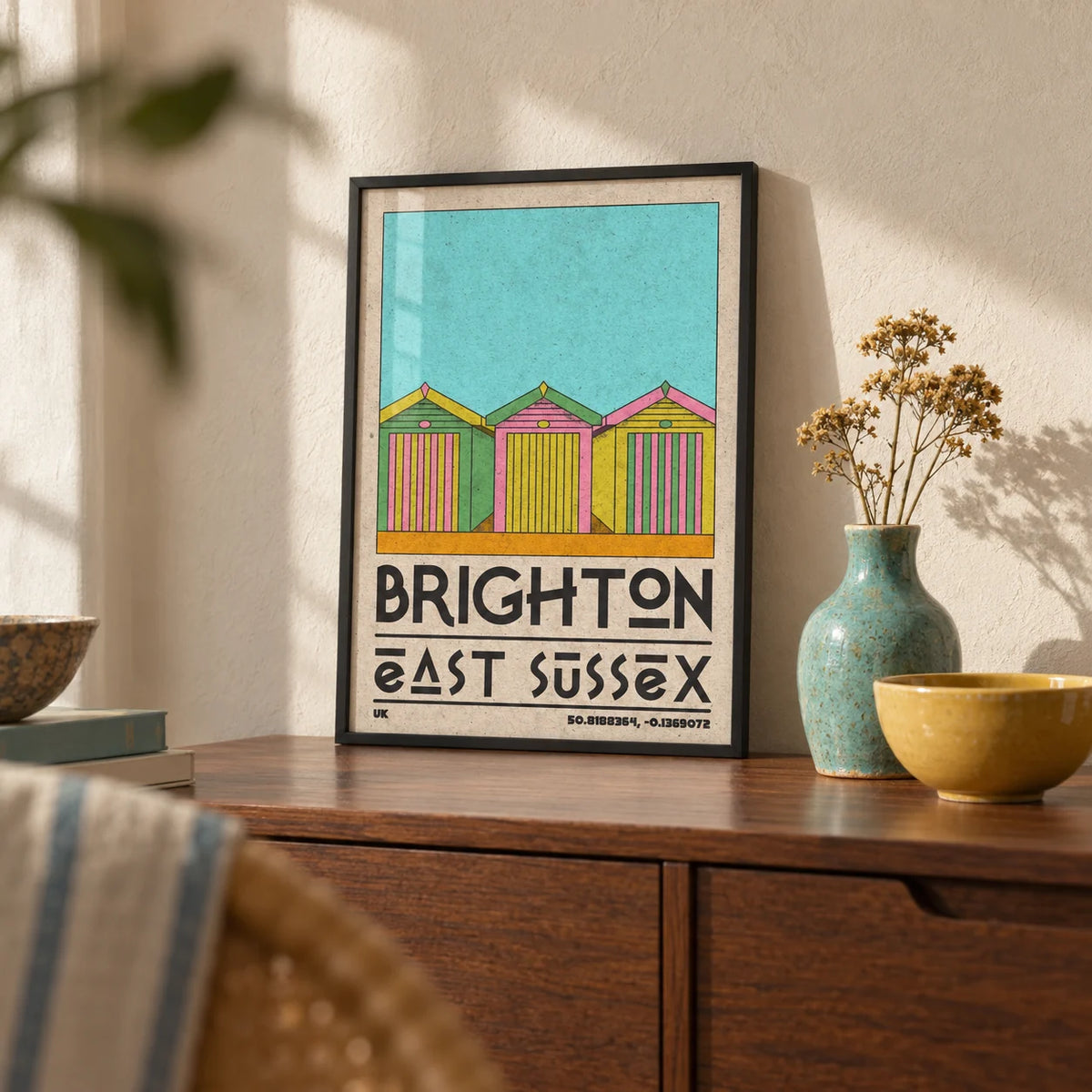 Brighton Travel Print, a small A4 framed print leaning on a walnut sideboard in a living room