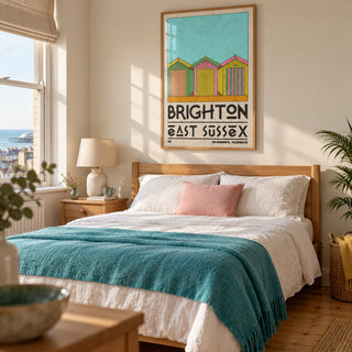 Brighton Travel Print, framed on the wall of a sunny adult bedroom in a coastal UK home with warm ivory walls and a restored pine floor