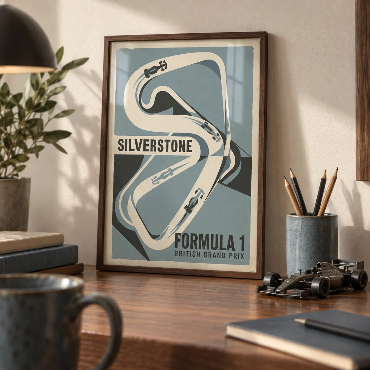 British Race Track Map Poster, a small A4 framed print leaning on a walnut desk