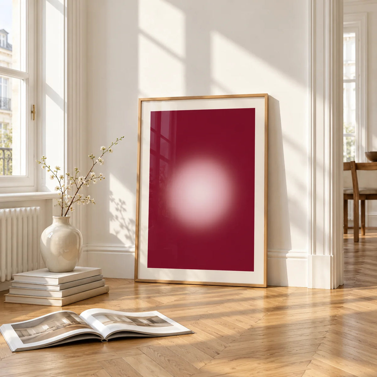 Burgundy Aura Print, framed and leaning on the parquet floor of a bright living room